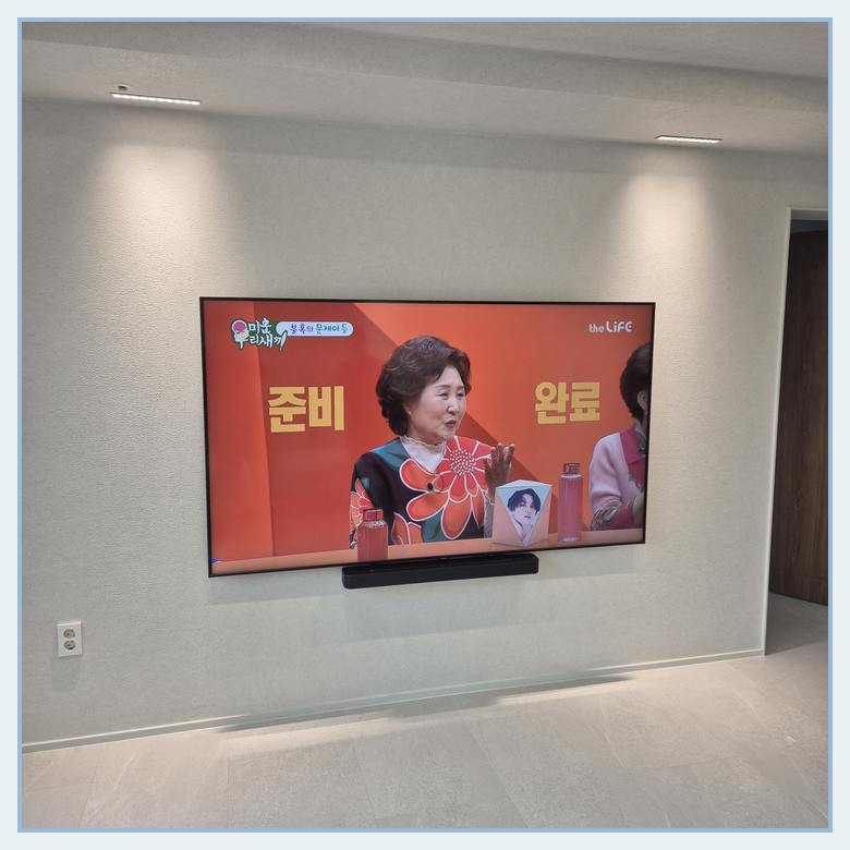거치대 위치를 정하기 전에 화면 배치를 비교하는 실제 벽걸이TV 사진 — 서초구 이전설치 참고