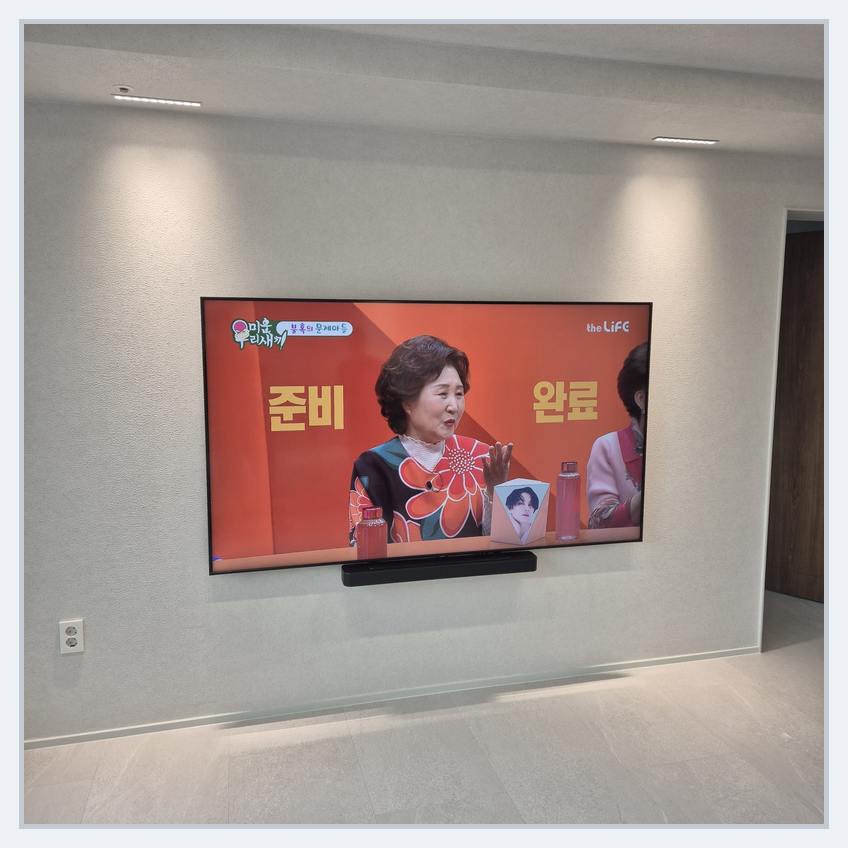 거치대 위치를 정하기 전에 화면 배치를 비교하는 실제 벽걸이TV 사진 — 77인치·85인치, 덕양·오정 이전 참고